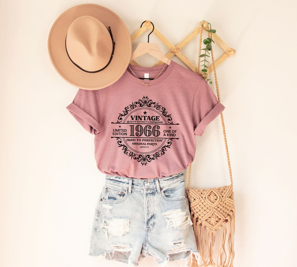 Vintage 1966 limited edition birthday shirt on a heather mauve Bella Canvas t-shirt worn with blue jeans and cardigan