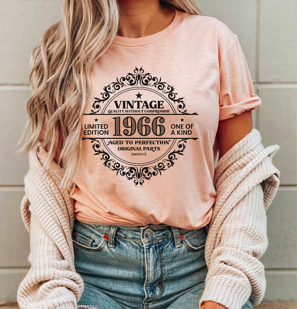 Vintage 1966 limited edition birthday shirt on a heather peach Bella Canvas t-shirt worn with blue jeans and cardigan